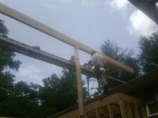 Carpenter setting a ridge beam over a new addition frame — Ice Dam Removal by Roofing Brothers in New Buffalo