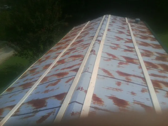 Rusted metal roof panels with new wood purlins before replacement — Storm Damage Roof Repair in New Buffalo by Roofing Brothers
